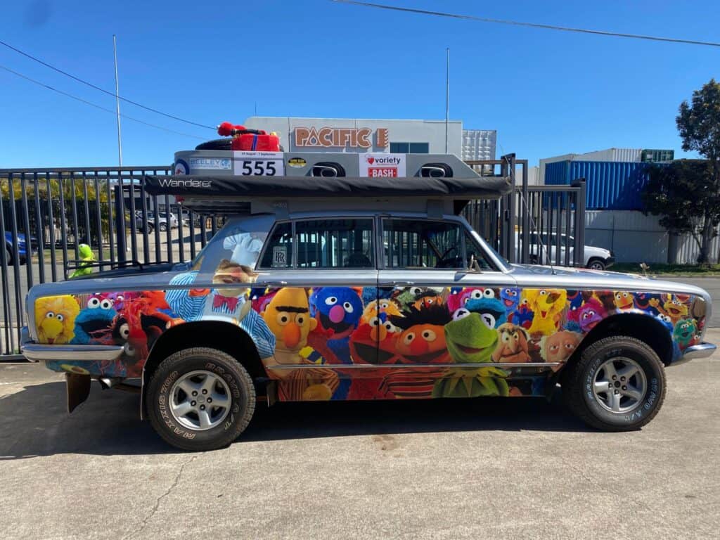 side on parked car with various Sesame Street characters wrapped on the car