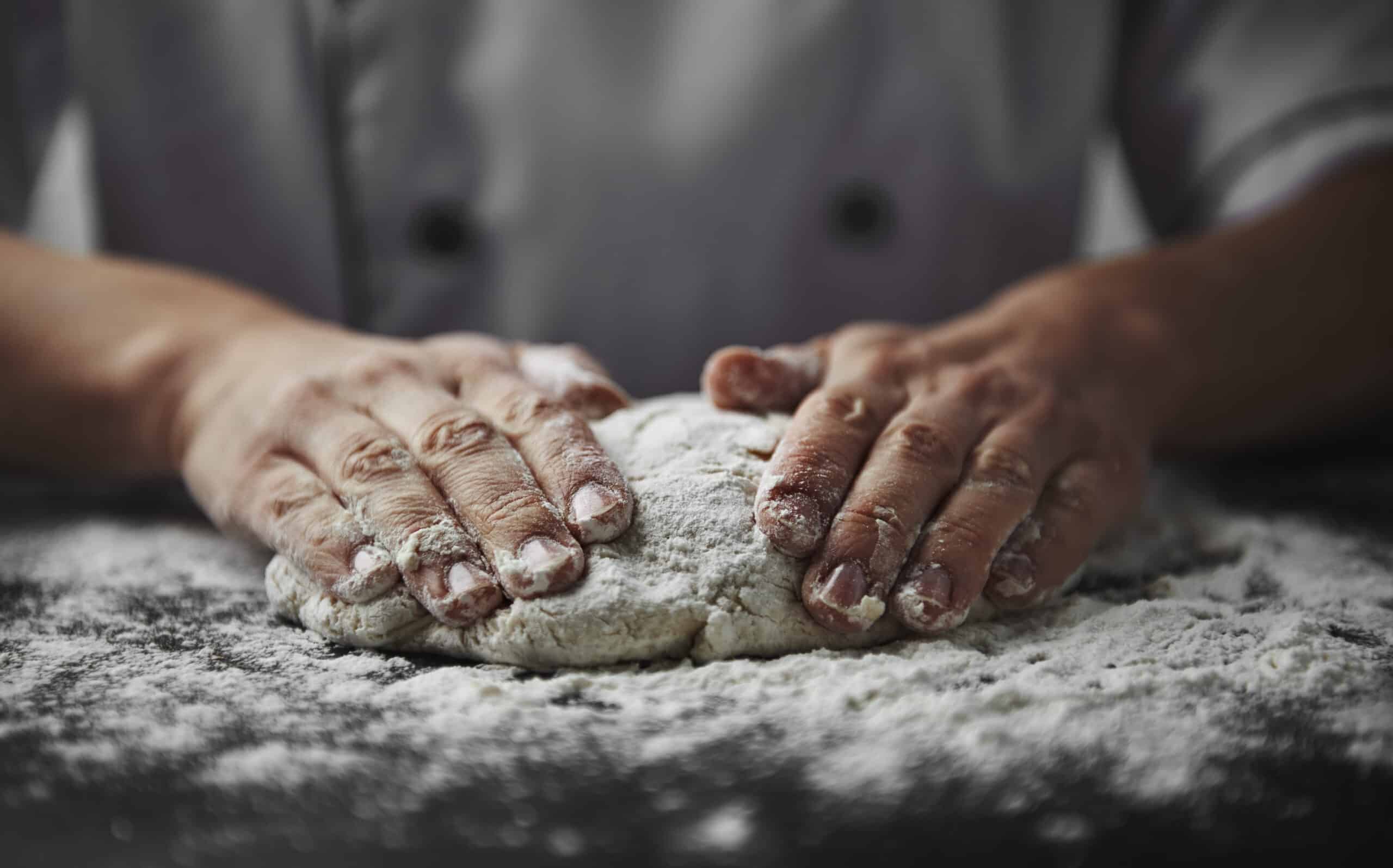 Close-up of a woman bakers hands kneading dough